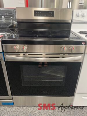 Stainless steel electric range with a black glass-ceramic cooktop and front control panel, in a showroom setting.